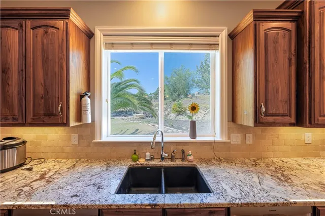 a kitchen with a sink a stove and wooden cabinets