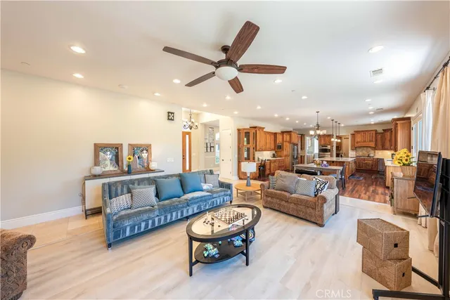 a living room with furniture kitchen view and a chandelier