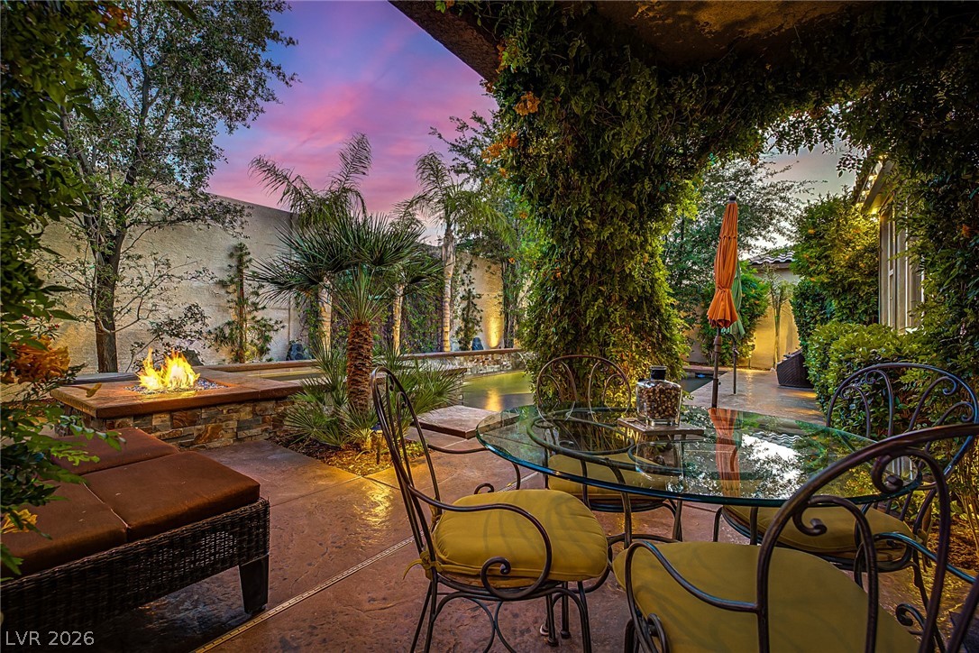 7415 Campbell Ranch Avenue Las Vegas, NV 89179 - Photo 42 of 52 An inviting outdoor living area with a cozy fire pit under a vibrant sunset sky.