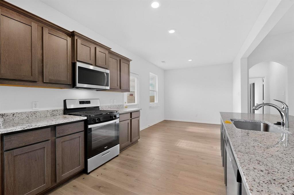 502 Monroe Jackson Street Venus, TX 76084 - Photo 15 of 40 a kitchen with stainless steel appliances granite countertop a sink stove and microwave