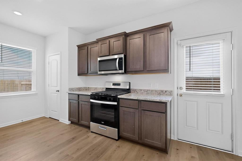 502 Monroe Jackson Street Venus, TX 76084 - Photo 16 of 40 a kitchen with a stove microwave and sink