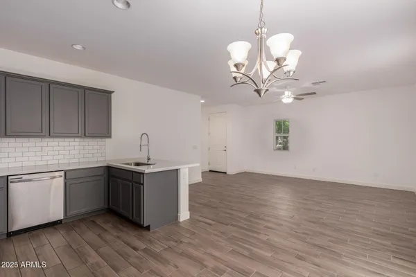 a kitchen with stainless steel appliances a refrigerator a sink dishwasher with wooden floor