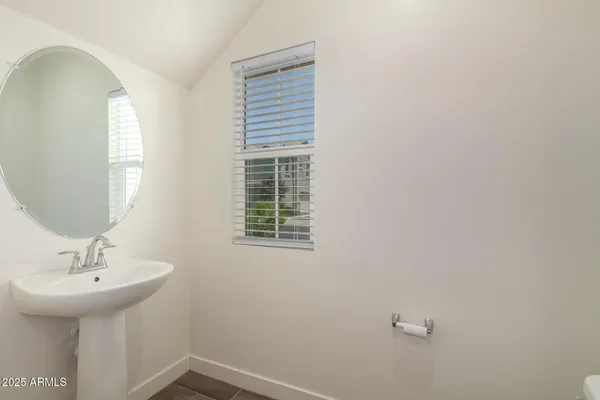 a view of an empty room with chandelier fan