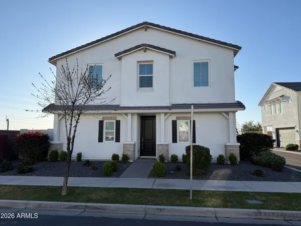 a front view of a house with garage and plants
