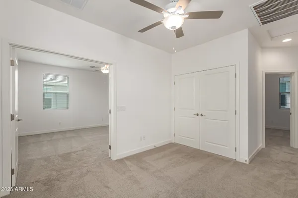 an empty room with windows and fan