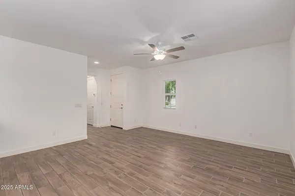 a view of a room with wooden floor and ceiling fan