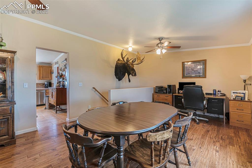 3180 Calhoun Byers Road Byers, CO 80103 - Photo 14 of 48 a view of a dining room with furniture and wooden floor