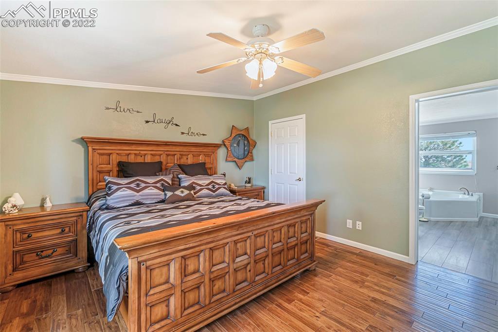 3180 Calhoun Byers Road Byers, CO 80103 - Photo 17 of 48 a bed sitting in a bedroom next to a window and a chandelier