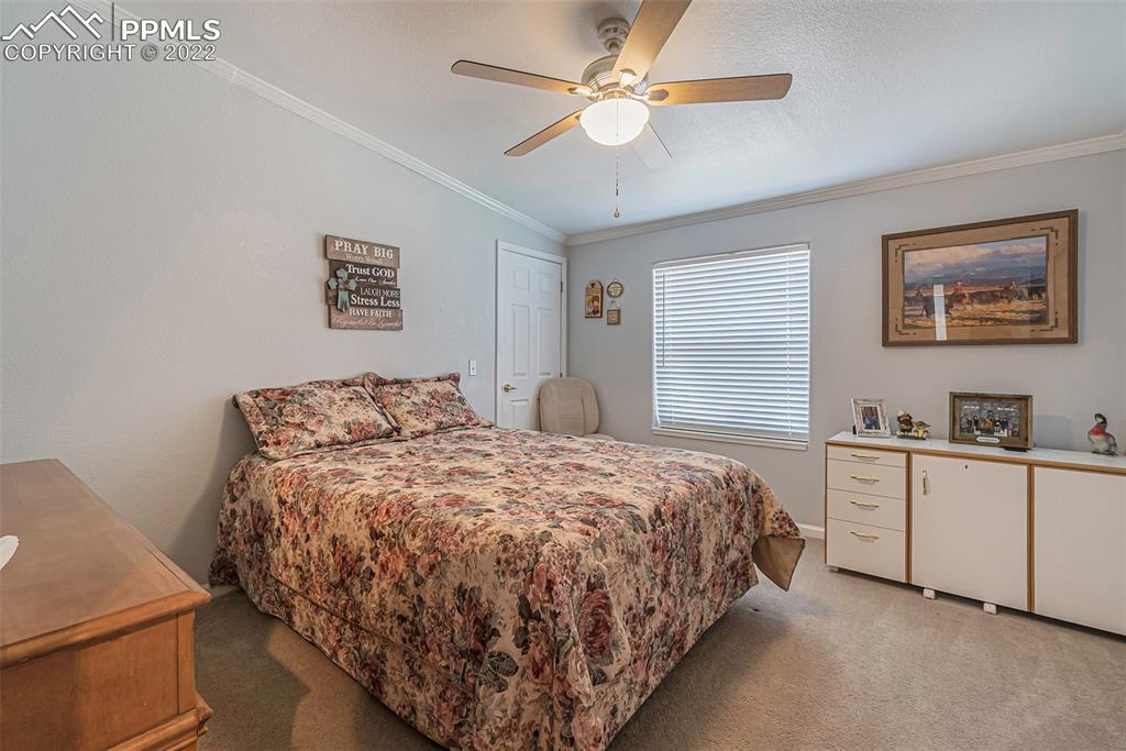 3180 Calhoun Byers Road Byers, CO 80103 - Photo 21 of 48 a bedroom with a bed and a chandelier