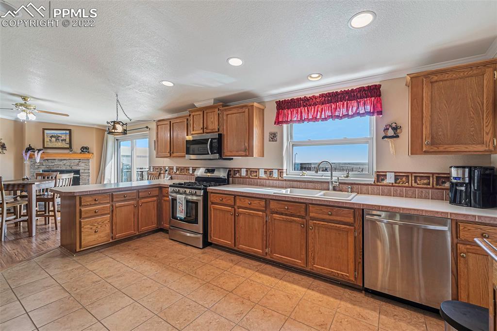 3180 Calhoun Byers Road Byers, CO 80103 - Photo 7 of 48 a kitchen with stainless steel appliances granite countertop a stove top oven a sink dishwasher and a refrigerator