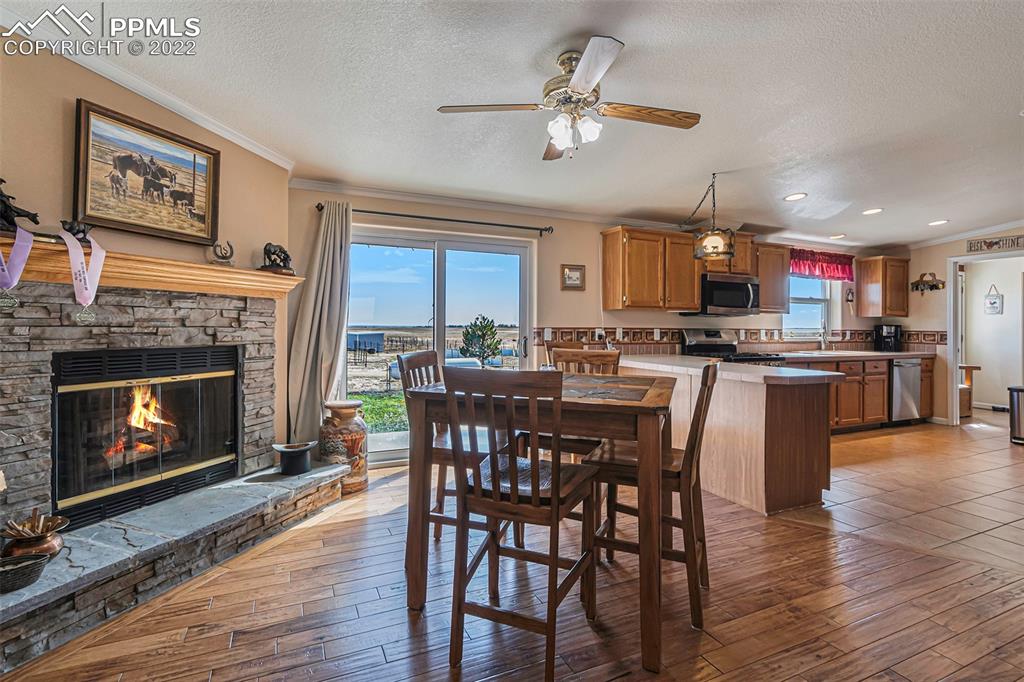 3180 Calhoun Byers Road Byers, CO 80103 - Photo 9 of 48 a view of a dining room with furniture a fireplace and wooden floor