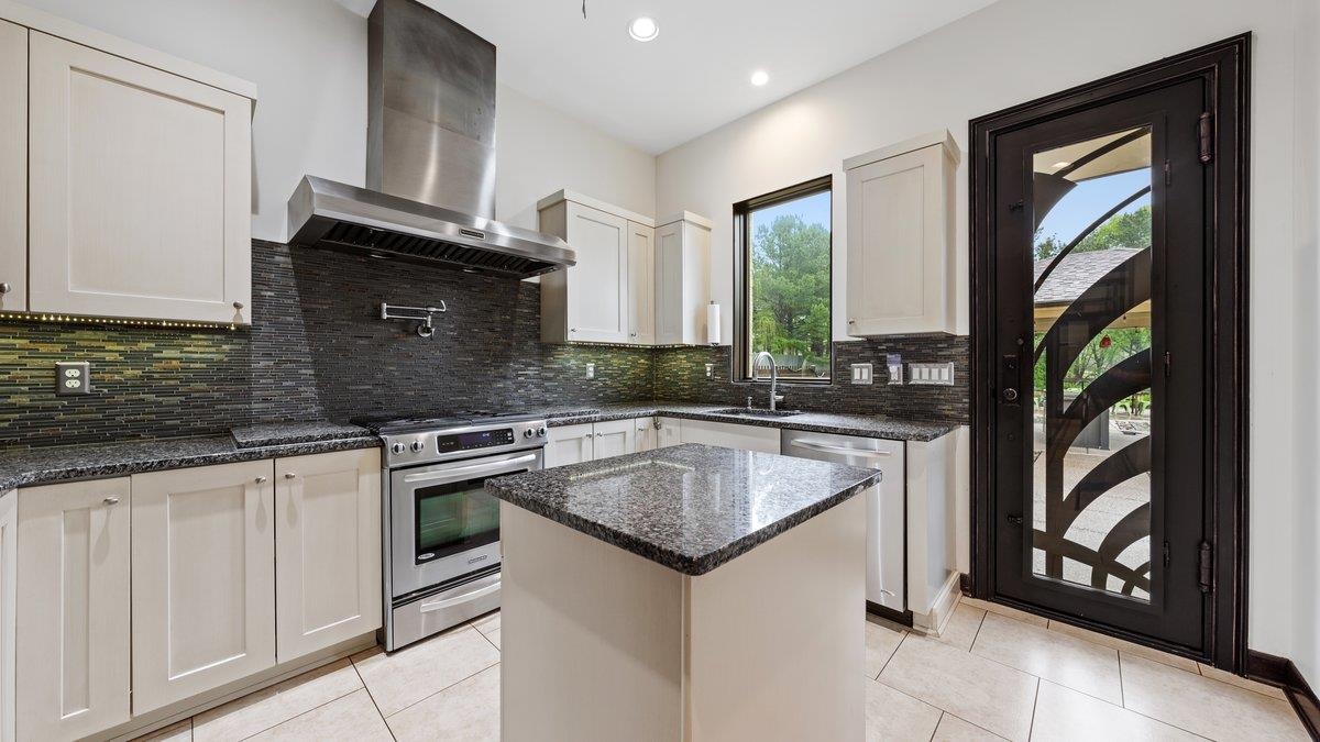 9942 Legends Drive Collierville, TN 38139 - Photo 17 of 40 a kitchen with granite countertop a sink stove and cabinets