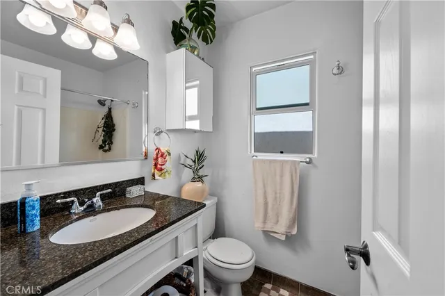 a view of a dining room with furniture a potted plant and wooden floor