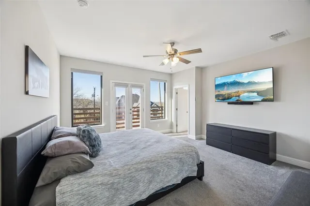 a bedroom with a bed couches and flat screen tv