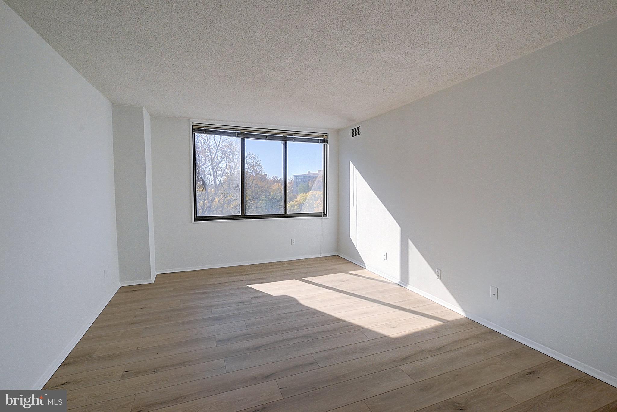 5225 Pooks Hill Road, Unit 911N Bethesda, MD 20814 - Photo 5 of 12 an empty room with wooden floor and windows