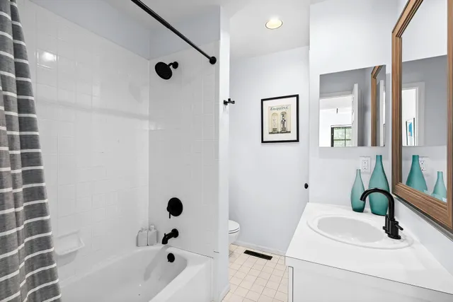 a bathroom with a tub sink and mirror