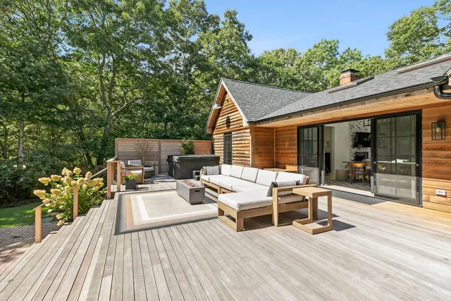 a view of a patio with table and chairs barbeque potted plants and large tree