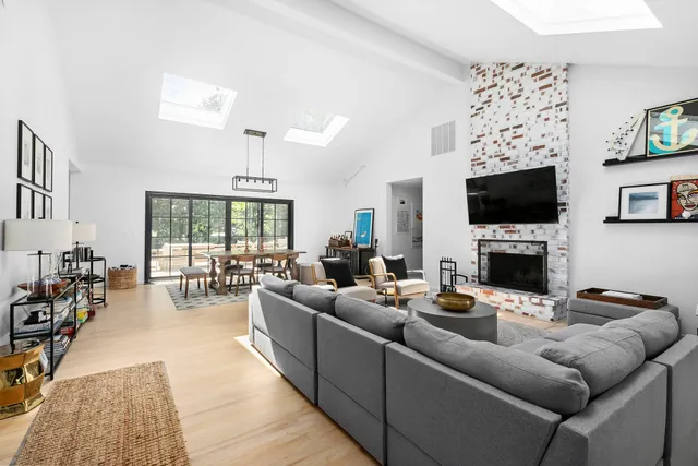 a living room with furniture a fireplace and a flat screen tv