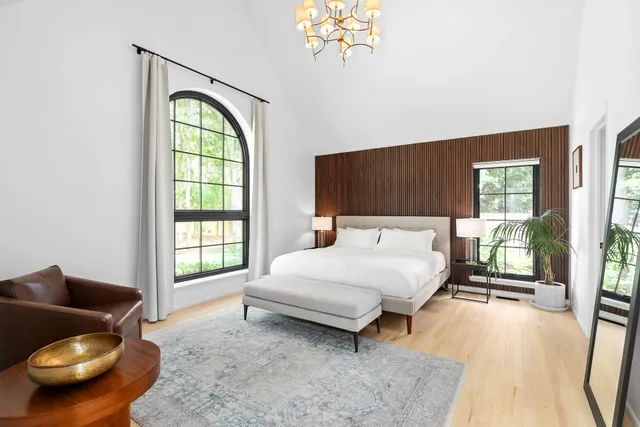 a spacious bedroom with a bed and glass window