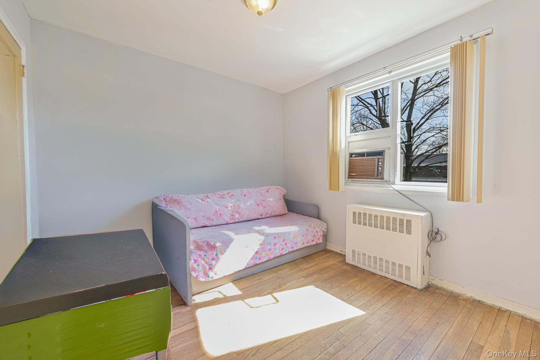 216-06 68th Avenue, Unit 2805 9 Queens, NY 11364 - Photo 7 of 14 a living room with furniture and a window