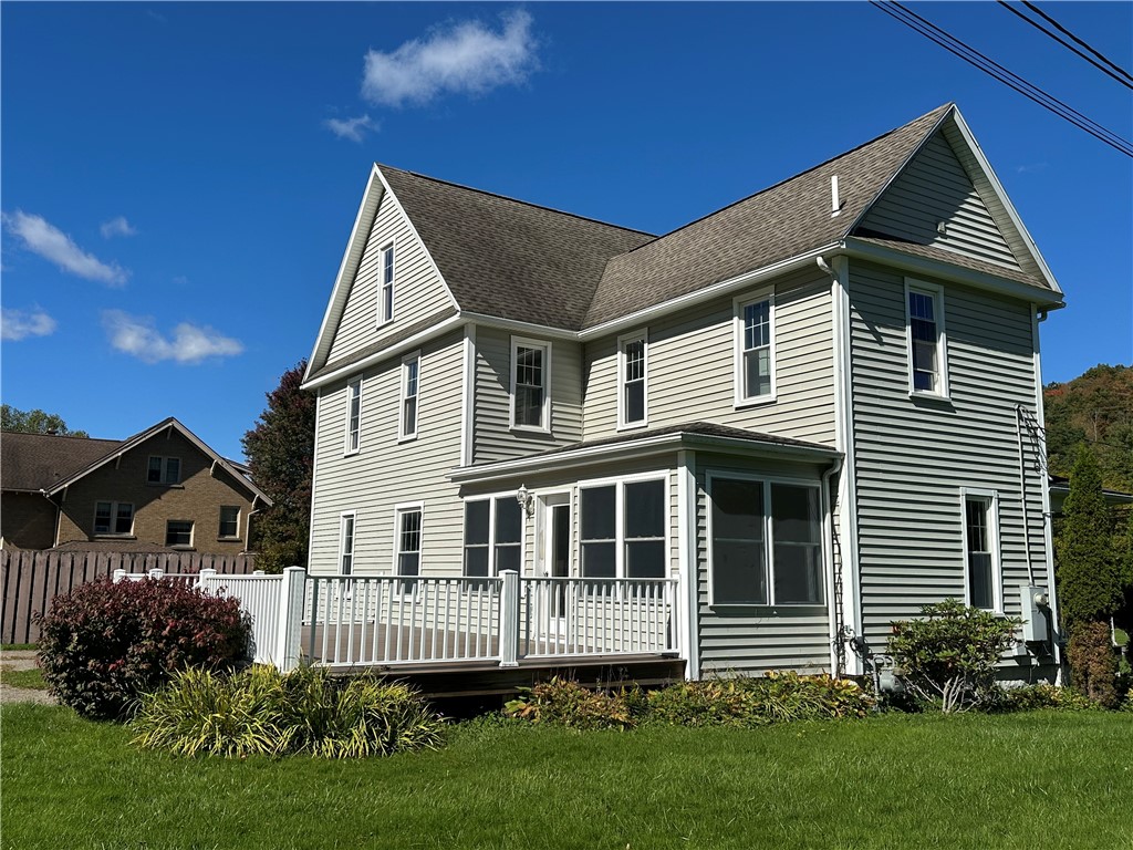 An expansive raised deck overlooks the grassy yard