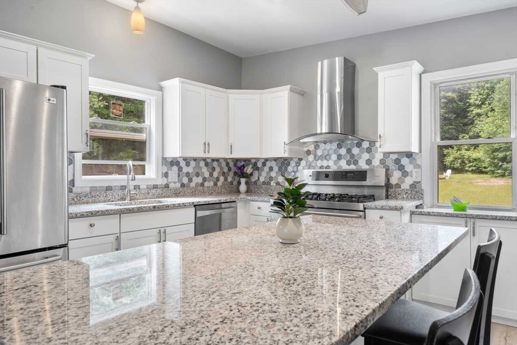 166 Packardville Road Pelham, MA 01002 - Photo 11 of 34 a kitchen with a stove a table and chairs in it