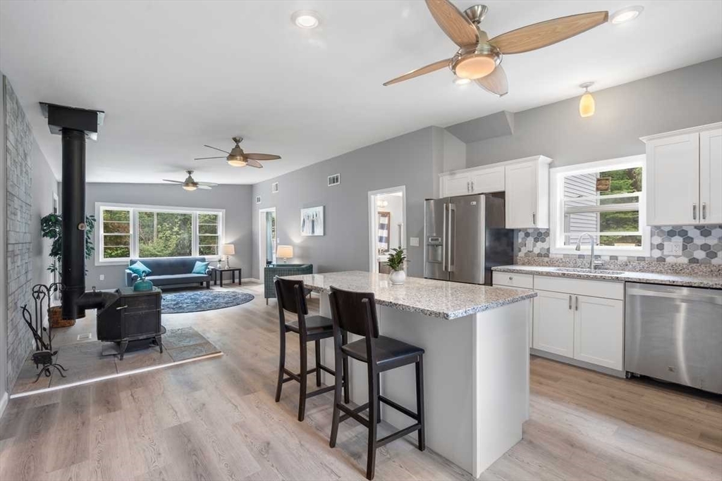 166 Packardville Road Pelham, MA 01002 - Photo 13 of 34 a open kitchen with stainless steel appliances granite countertop a stove a sink dishwasher a dining table and chairs with wooden floor