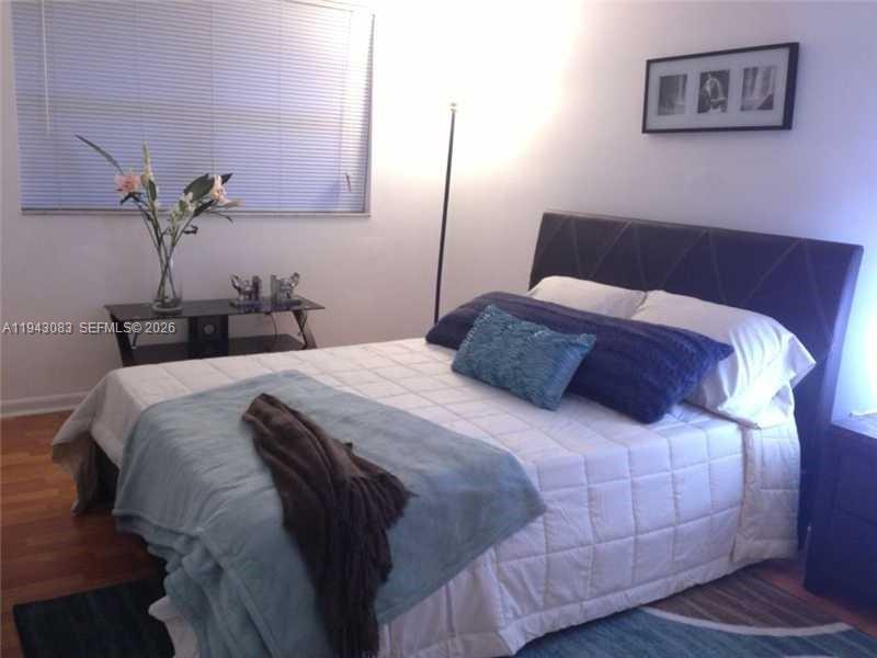 a bedroom with a bed and a potted plant on dresser