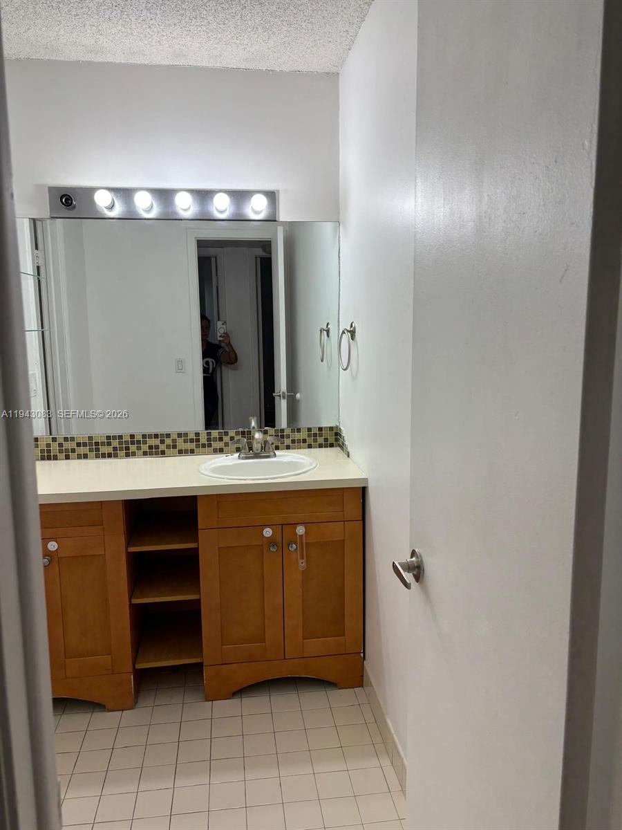 15600 Southwest 80th Street, Unit L302 Miami, FL 33193 - Photo 11 of 16 a bathroom with a double vanity sink and a mirror