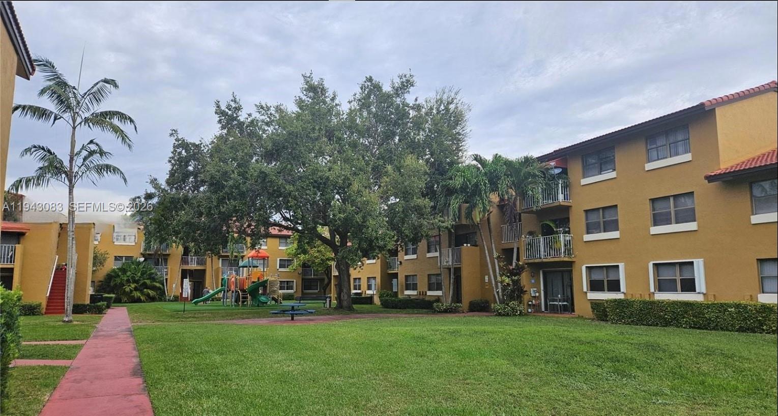 15600 Southwest 80th Street, Unit L302 Miami, FL 33193 - Photo 14 of 16 a view of a building with a yard