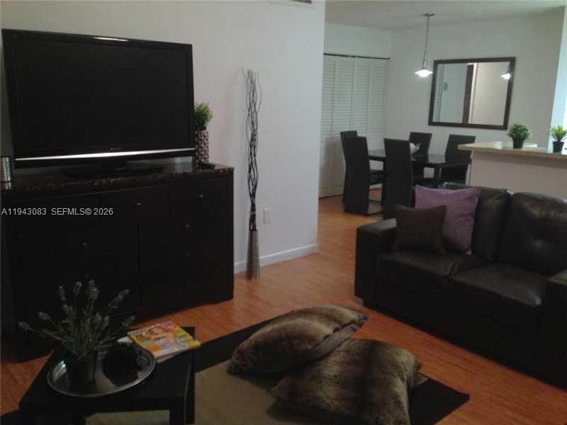 15600 Southwest 80th Street, Unit L302 Miami, FL 33193 - Photo 6 of 16 a living room with furniture and a flat screen tv