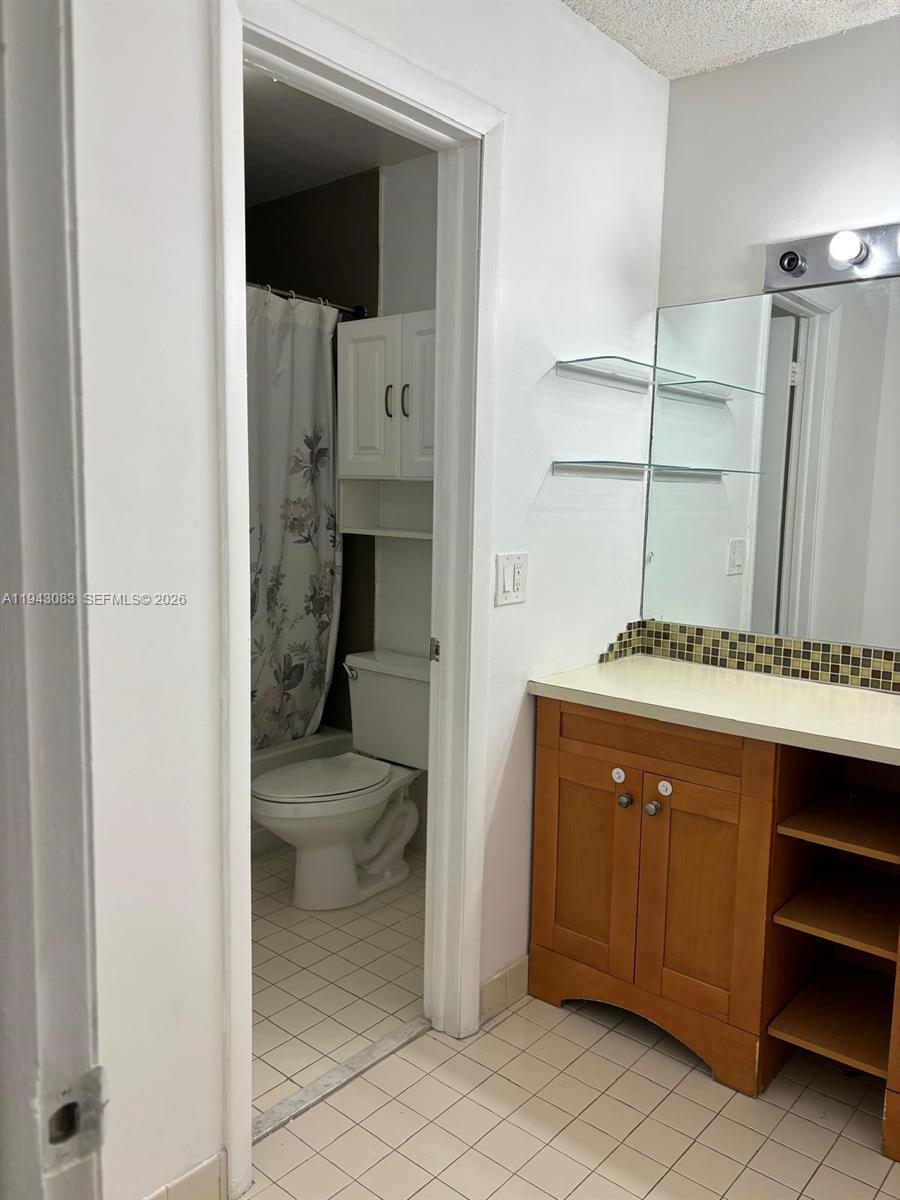 15600 Southwest 80th Street, Unit L302 Miami, FL 33193 - Photo 10 of 16 a en suite bathroom with a sink toilet and mirror