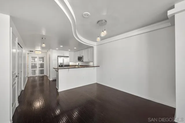 a kitchen with granite countertop a sink and a white cabinets