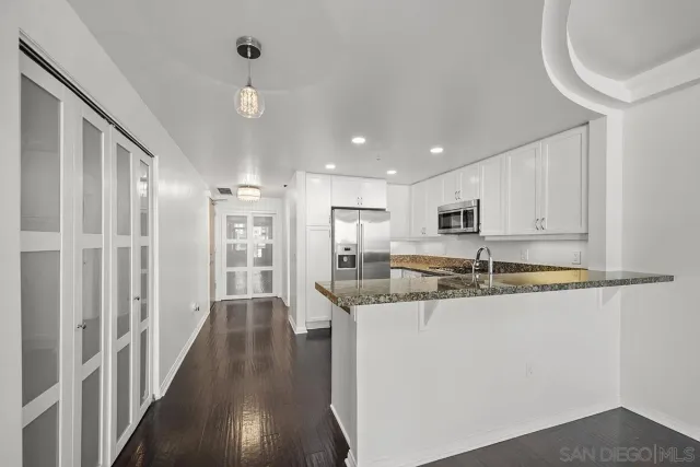 a bathroom with a granite countertop sink a mirror and a shower
