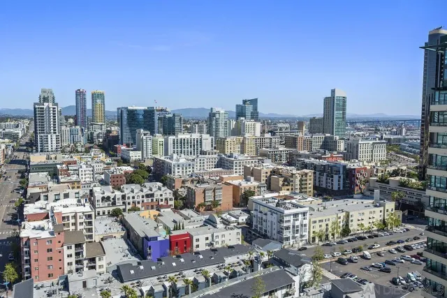 a large kitchen with granite countertop a large kitchen island white cabinetry and stainless steel appliances