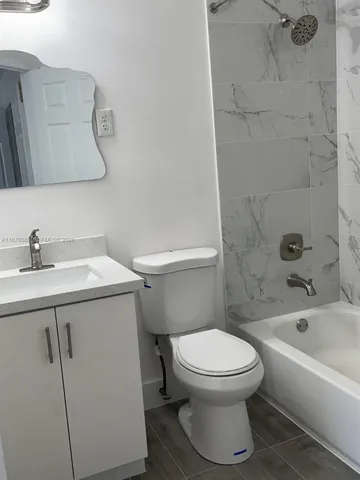 a white toilet sitting next to a bath tub