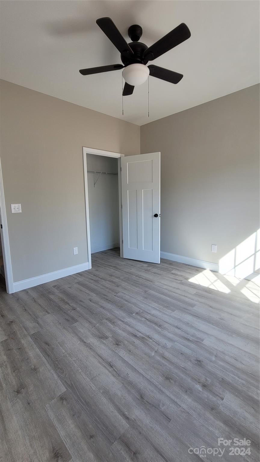 308 Pamela Road, Unit 5 York, SC 29745 - Photo 8 of 20 an empty room with wooden floor ceiling fan and window