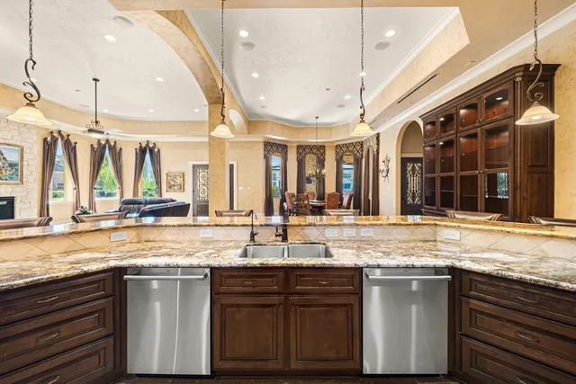 a kitchen with granite countertop a sink a stove and cabinets