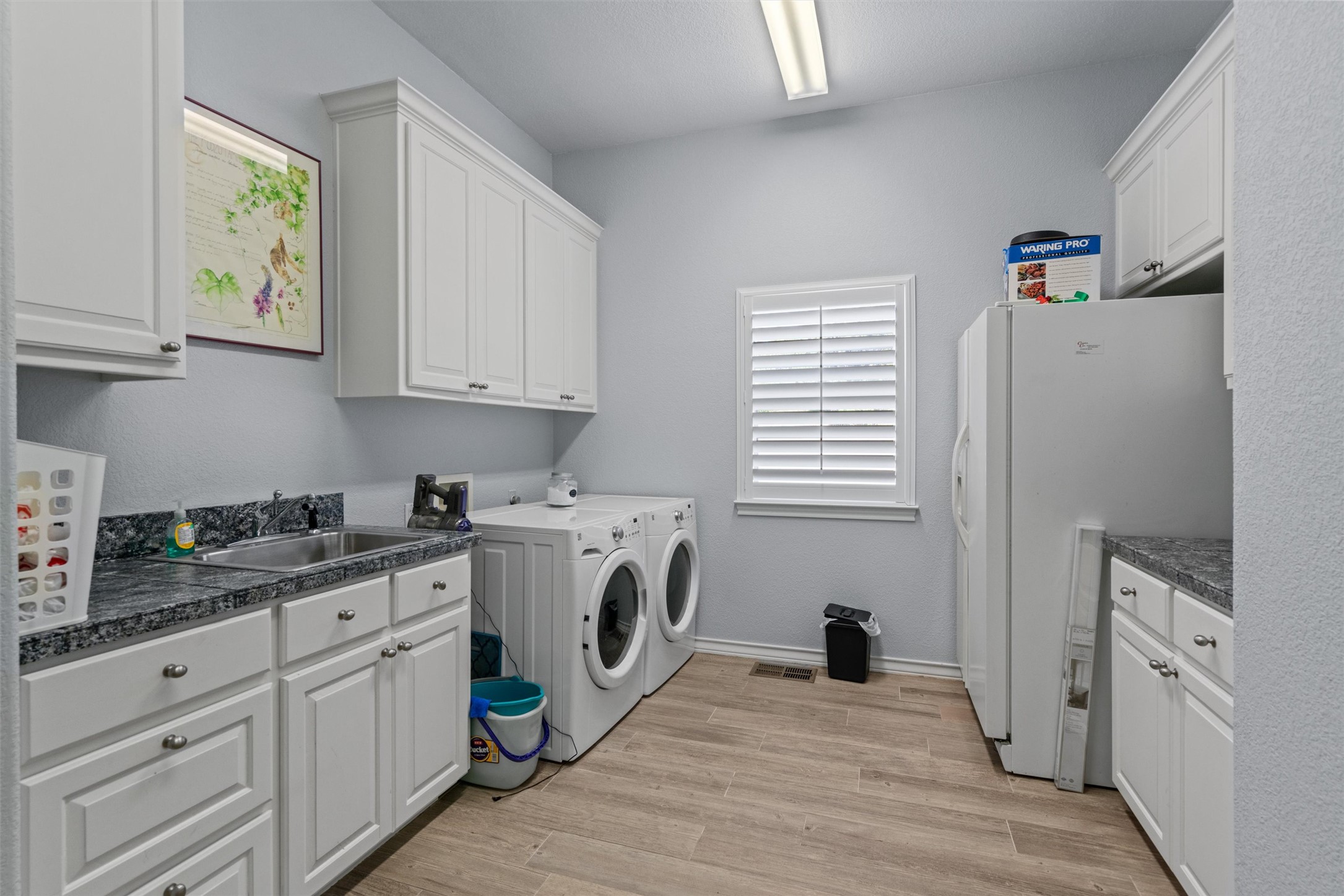 4401 Sunset Cliff Road Burnet, TX 78611 - Photo 19 of 40 Spacious laundry room with custom cabinetry, utility sink, and central vacuum—designed for effortless functionality.