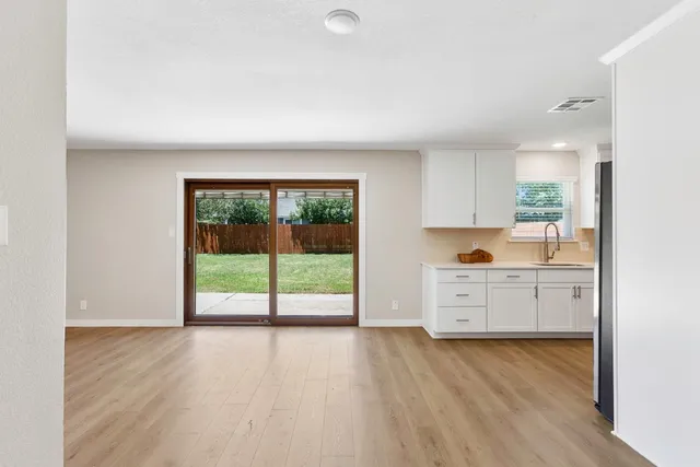 a view of a kitchen with wooden floor and a window