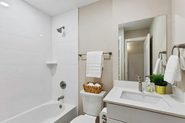 a bathroom with a sink a toilet a mirror and shower