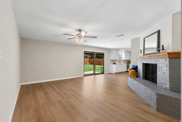 a view of a livingroom with a fireplace a chandelier and wooden floor