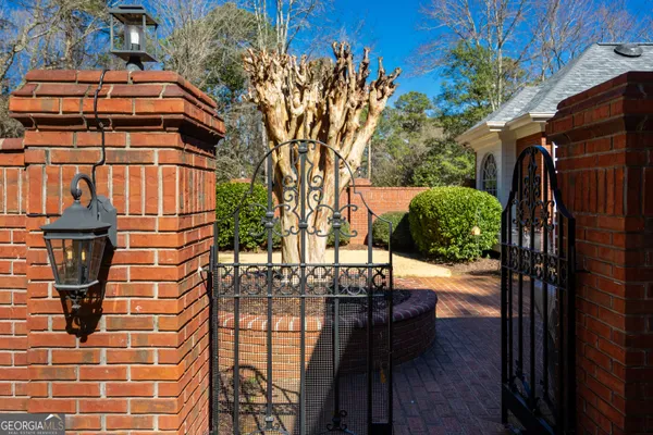 a view of a patio with table and chairs potted plants and a large tree