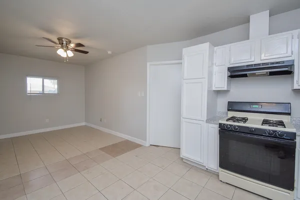 a kitchen with white cabinets and appliances