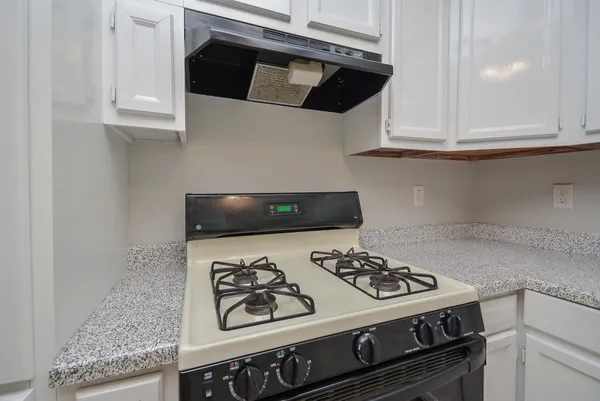a stove top oven sitting inside of a kitchen