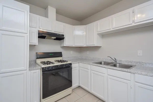 a kitchen with white cabinets and appliances