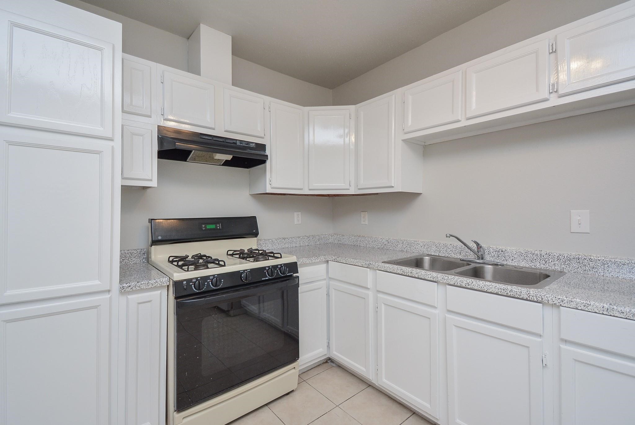 2117 Thonig Road, Unit B Houston, TX 77055 - Photo 14 of 25 a kitchen with white cabinets and appliances