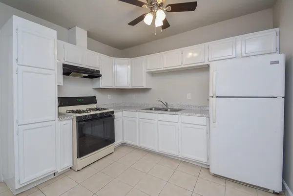 a kitchen with stainless steel appliances granite countertop a refrigerator sink and stove