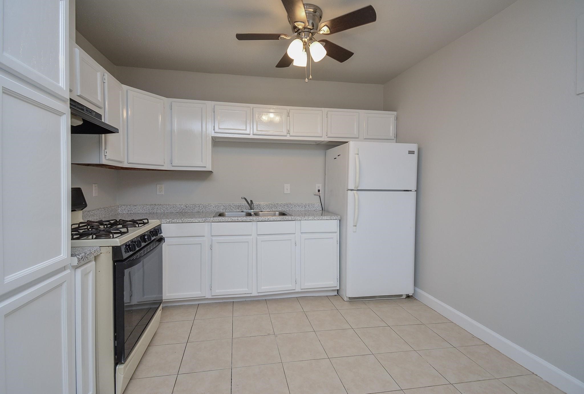 2117 Thonig Road, Unit B Houston, TX 77055 - Photo 17 of 25 a kitchen with cabinets appliances and a ceiling fan