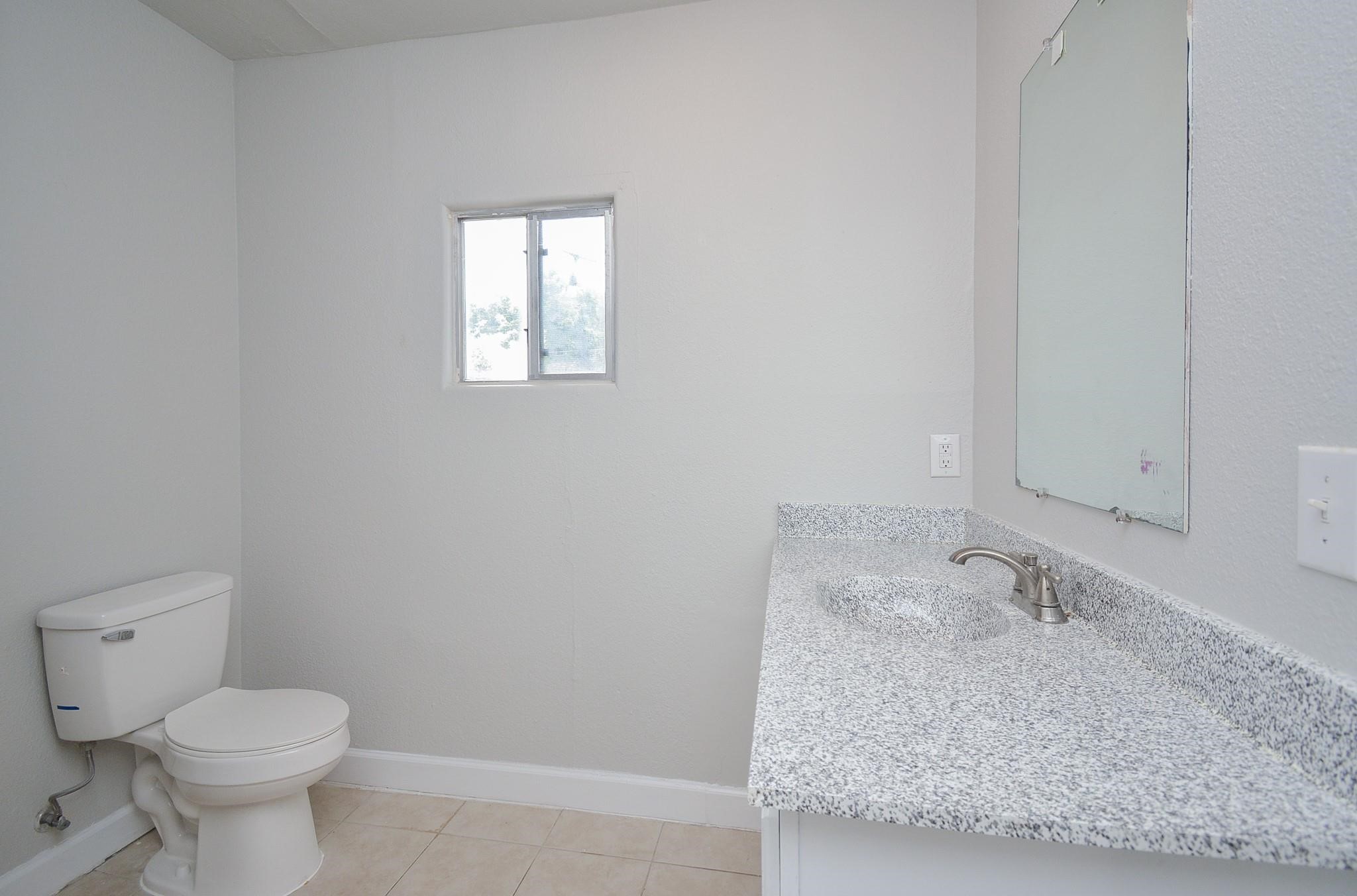 2117 Thonig Road, Unit B Houston, TX 77055 - Photo 23 of 25 a bathroom with a granite countertop sink and a toilet